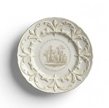 Dekorativ tallerken med reliefmønster og klassisk motiv